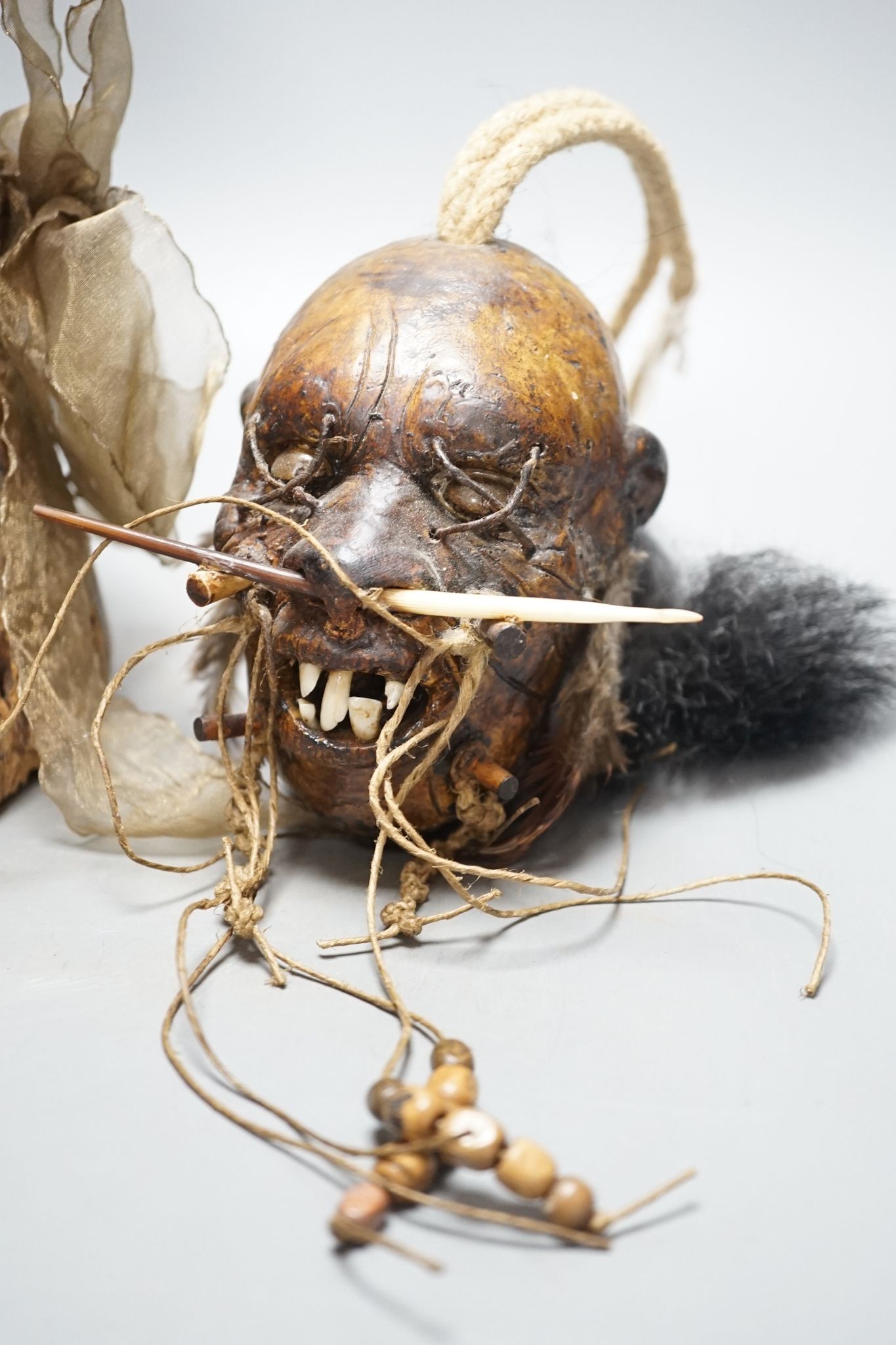 An African tribal carving, 31cm and a pottery model of a shrunken head